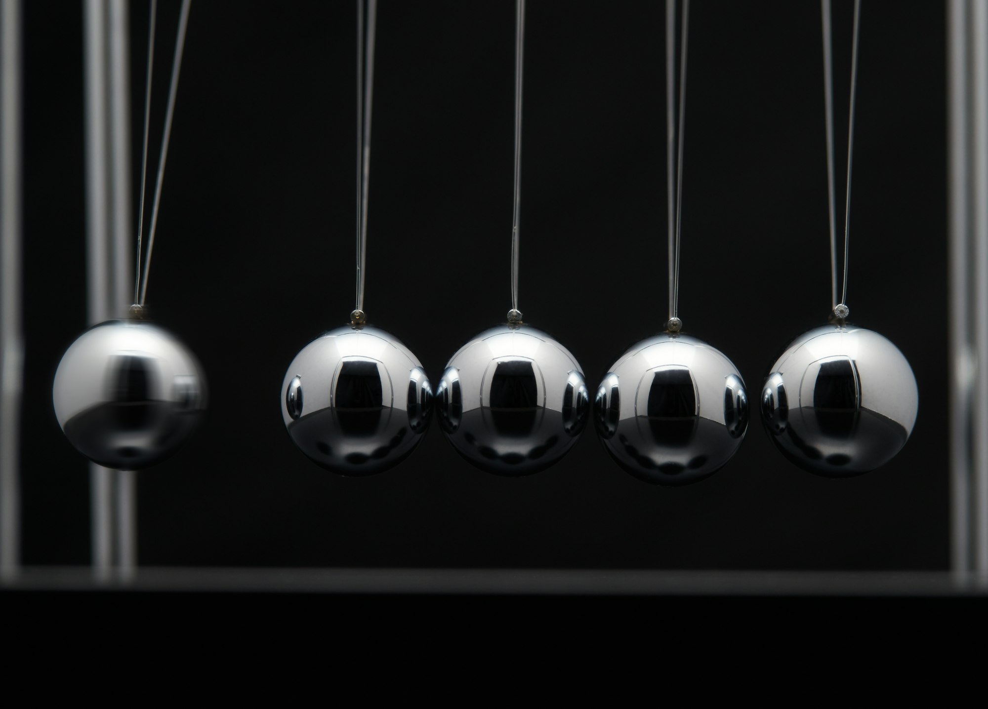 Closeup Of Newton Cradle With Swinging Metal Balls